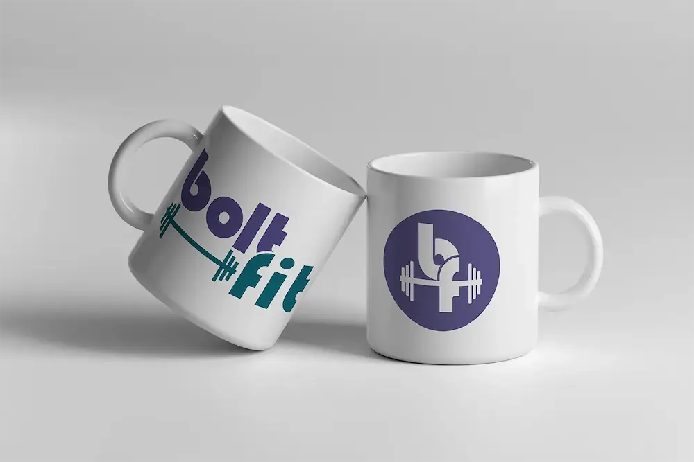 Branded promotional merchandise showing BoltFit logo on matte black mugs
