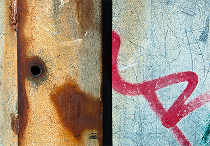 Photo of a closeup of a rusty container with rust and graffiti 